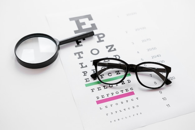 High angle alphabet table with magnifier and glasses