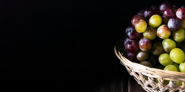 High angle of autumn grapes in basket with copy space