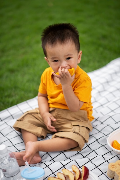 High angle baby sitting on cloth outdoors