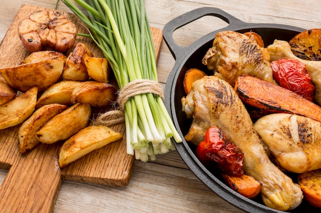 High angle baked chicken and veggies in pan with potatoes and green onions