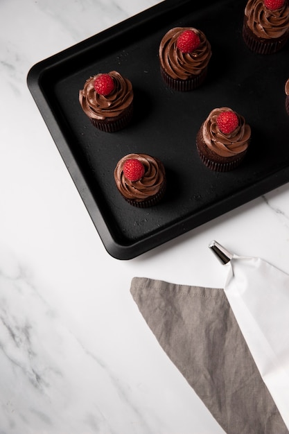 High angle of delicious chocolate cupcakes with raspberry