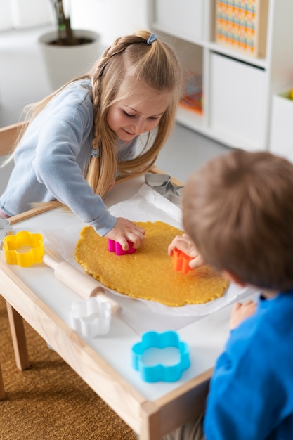 High angle kids making cookies together