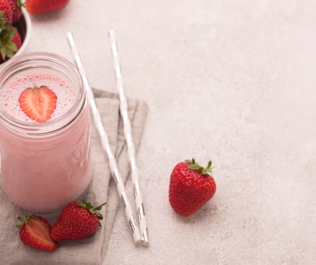 High angle of milkshake with strawberries and copy space