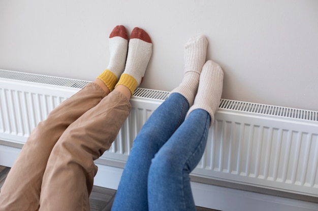 Photo high angle people's legs laying on heater