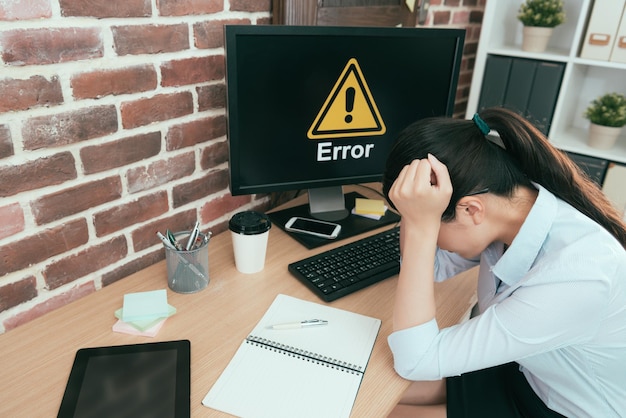 Photo high angle photo of office computer getting mistake problem showing error symbol let manager can't work and sitting on desk feeling upset.