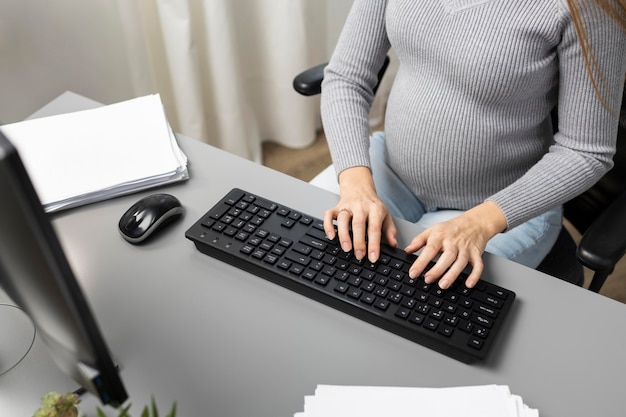 High angle of pregnant businesswoman working on computer