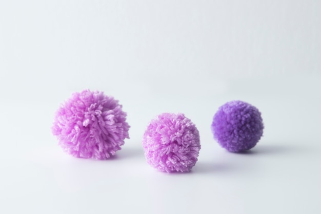 High angle purple pom poms on white background