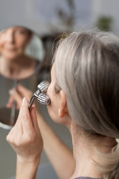 High angle senior woman massaging face