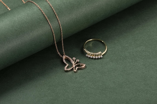 High angle shot of a beautiful ring and necklace on a green surface