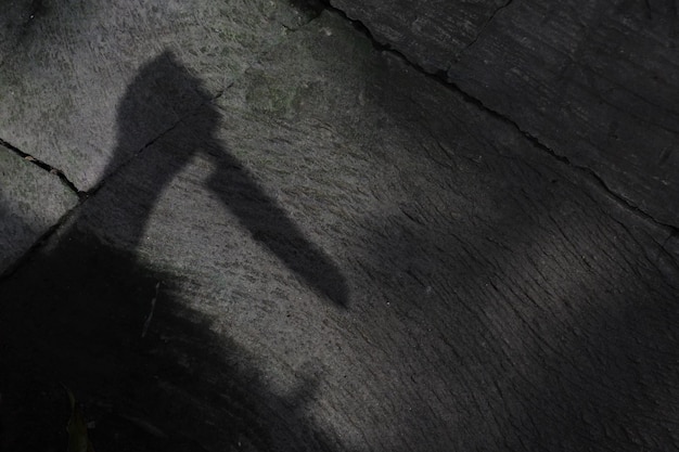 High angle shot of a shadow of human hand holding a knife- murder concept