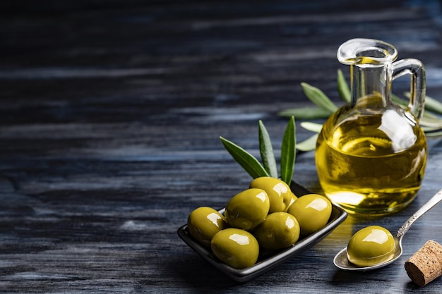 High angle shot of tasty looking green olives near an olive oil