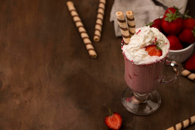 Photo high angle of strawberry milkshake with cream and copy space