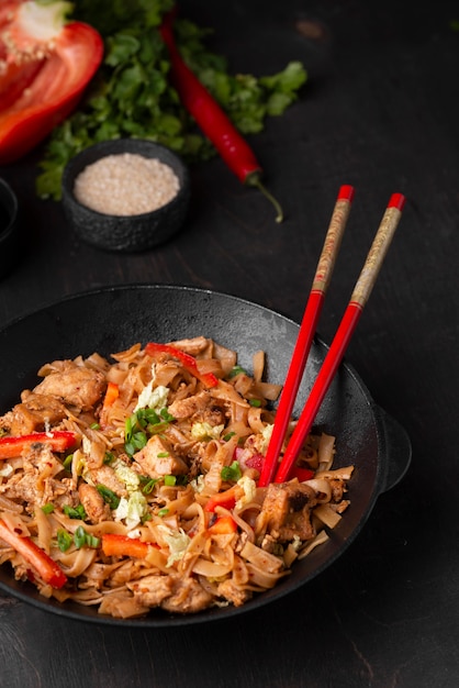 High angle of traditional asian dish with chopsticks and herbs