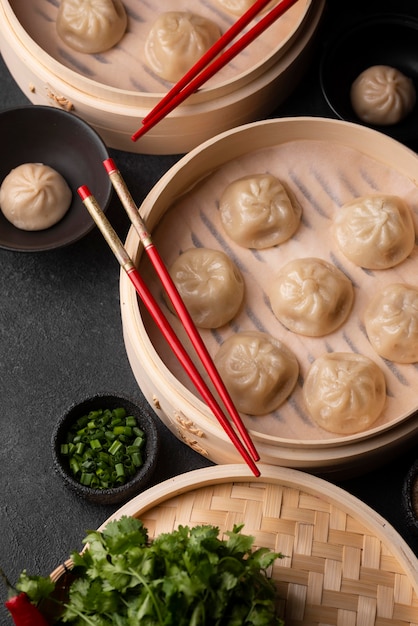 High angle of traditional asian dumplings with chopsticks and herbs