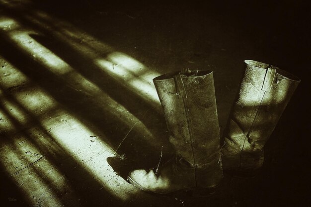 Photo high angle view of abandoned boots on floor