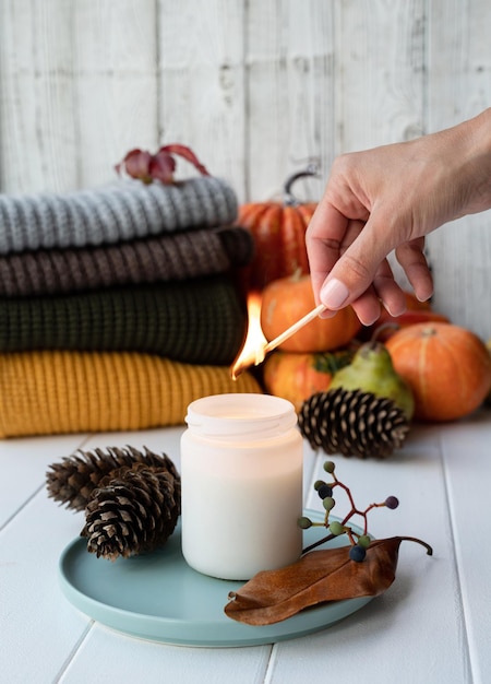 High angle view autumn composition with sweaters and candles white candle mockup design