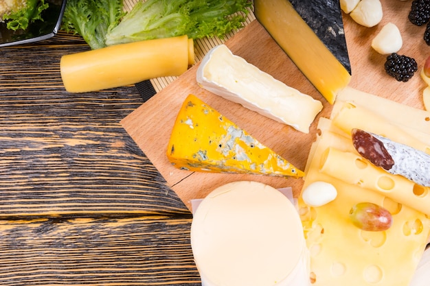 High Angle View of Cheese Platter with Variety of Cheeses on Board with Copy Space on Rustic Wooden Table