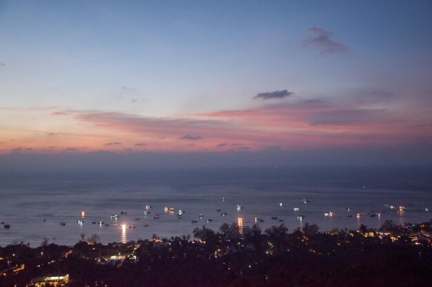 High angle view of city lit up at sunset