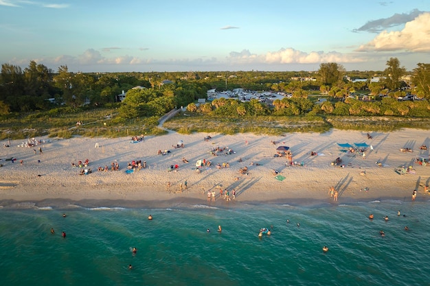 High angle view of crowded Nokomis beach in Sarasota County USA Many people enjoing vacations time swimming in ocean water and relaxing on warm Florida sun at sundown