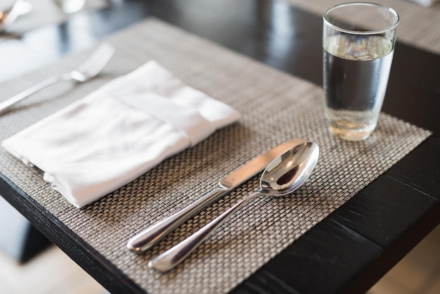 Photo high angle view of cutlery and napkin on place mat at dining table