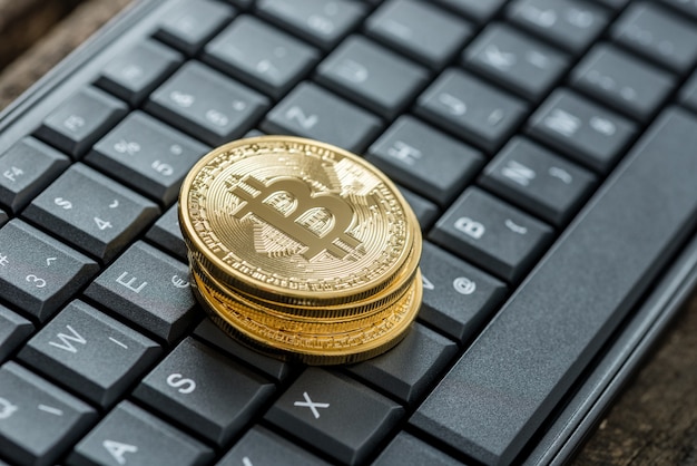 High angle view of four golden bitcoins on a keyboard as concept for digital earnings and currency.