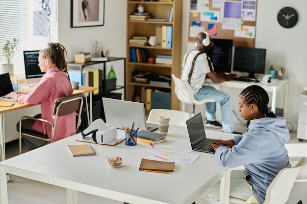 High angle view of group of young programmers working on computers in it office