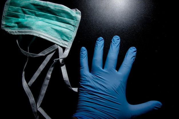 Photo high angle view of human hand by mask against black background