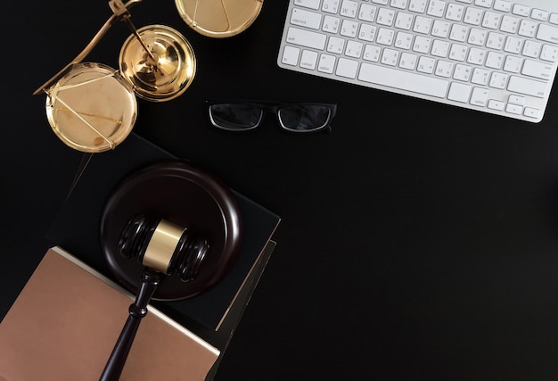 Photo high angle view of laptop with gavel and weight scale on black background