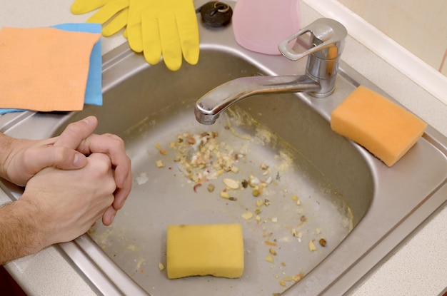 High angle view of man standing by dirty sink at kitchen