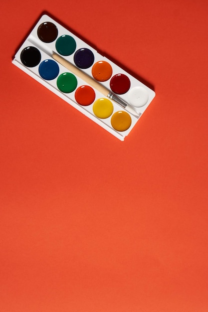 High angle view of multi colored pencils against orange background