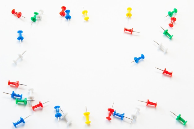 Photo high angle view of multi colored thumbtacks against white background