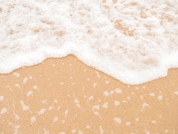 high angle view. Ocean waves hit the beach or shore and air bubbles. Wet sand, sea water