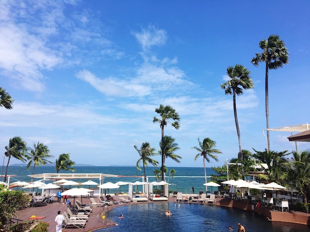 Photo high angle view of people at swimming pool by sea against sky