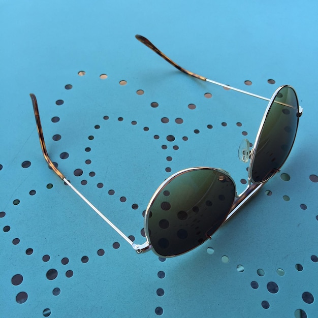 Photo high angle view of sunglasses on blue table