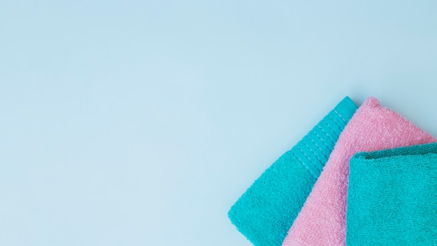 High angle view of three towels on blue background