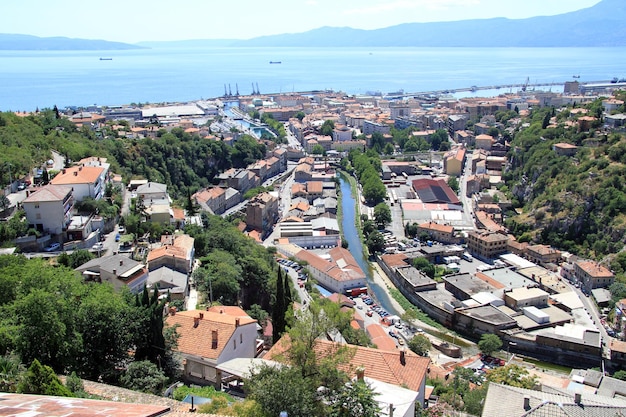 High angle view of townscape by sea against sky