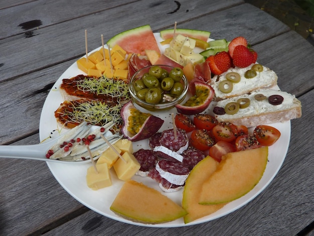 Photo high angle view of various fruits in plate on table