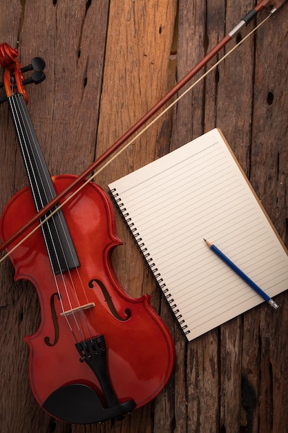 High angle view of violin by spiral notebook and pencil on table