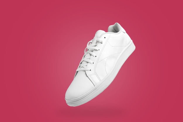 High angle view of white sneaker isolated on magenta (Viva Magenta) background. Sportive pair.