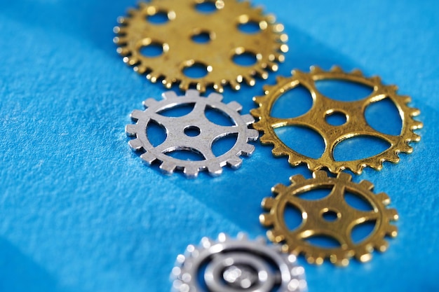 High angle wheel group of cog gear wheels against blue background