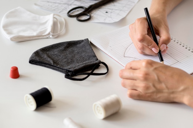 High angle of woman designing face mask to sew