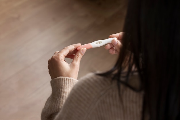 High angle woman holding pregnancy test