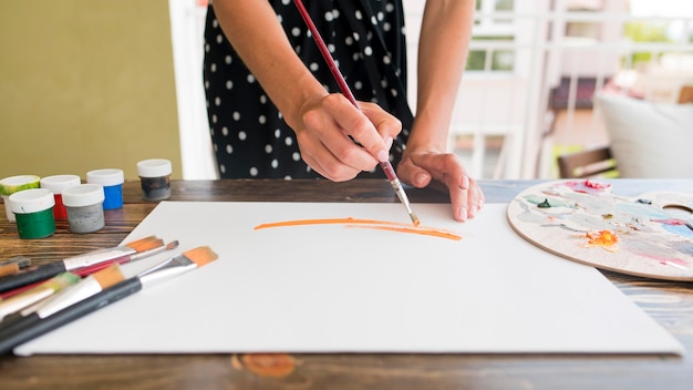 High angle of woman painting canvas with brush and palette