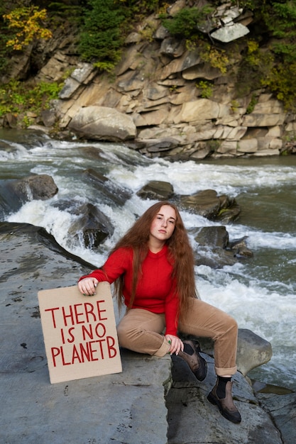 High angle woman sitting on rock with banner