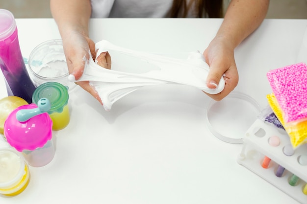 High angle of young girl scientist experimenting with slime