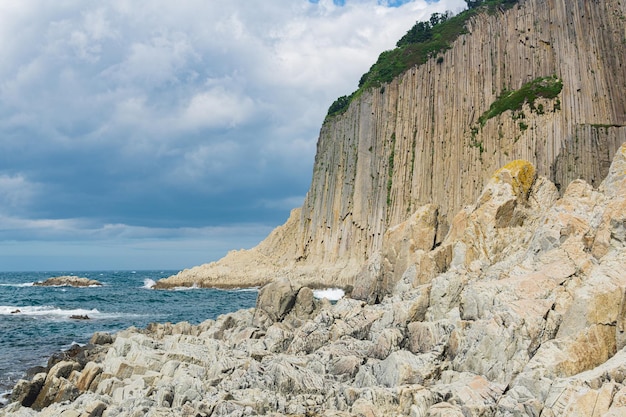 High coastal cliff formed by stone columns Cape Stolbchaty on the island of Kunashir