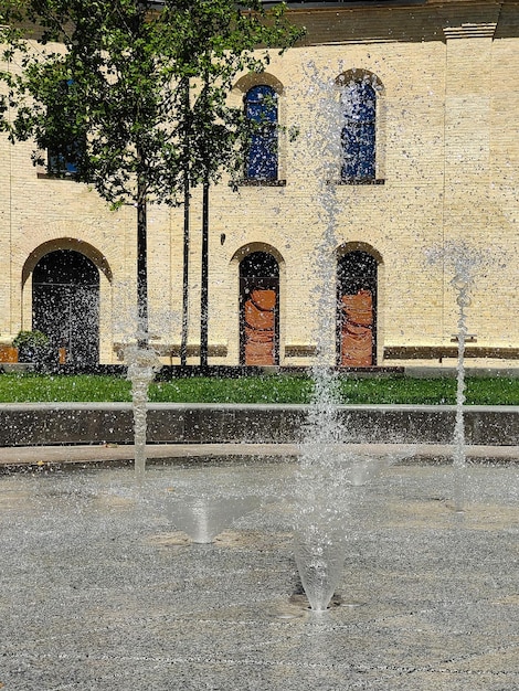 High jets of fountains on gray ceramic tiles at short exposure