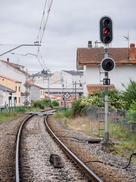 High railway entrance E1 sign at the Monforte de Lemos station indicating a stop in red on its lamp and the ASFA beacon at the foot of the associated signal located between the rails of the track