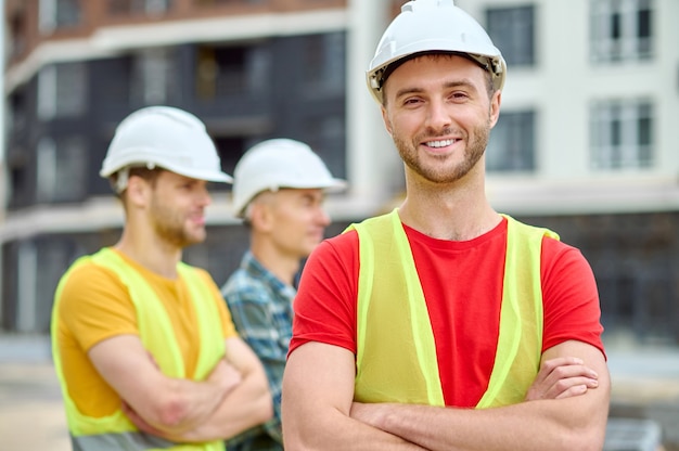 High-spirited construction worker in a protective helmet looking ahead