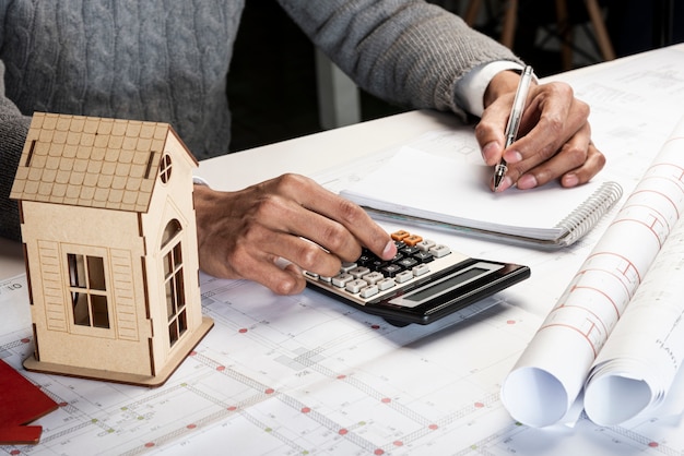 High view left handed person calculating and writing